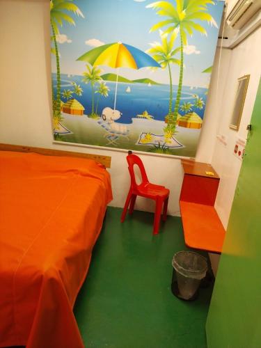 a bedroom with an orange bed and a painting on the wall at WISMA ORCHID HOMESTAY Tuaran in Tuaran