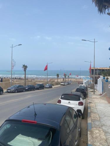 uma fila de carros estacionados junto à praia em Sable d’or em Plage de Mehdia