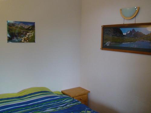 une chambre avec un lit et un tableau au mur dans l'établissement appartement avec parking interieur drap non fourni, à Saint-François-Longchamp