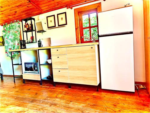 a kitchen with a white refrigerator and a wooden floor at Romantic Private Cabin in Estepona