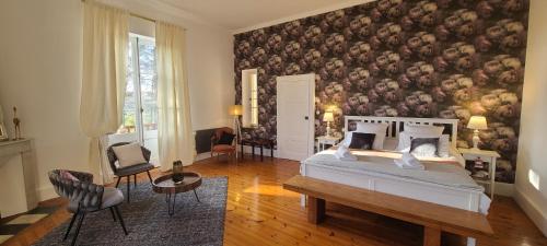 um quarto com uma cama com uma grande parede floral em Le Manoir du Moulin de Madame em Villeneuve-sur-Lot