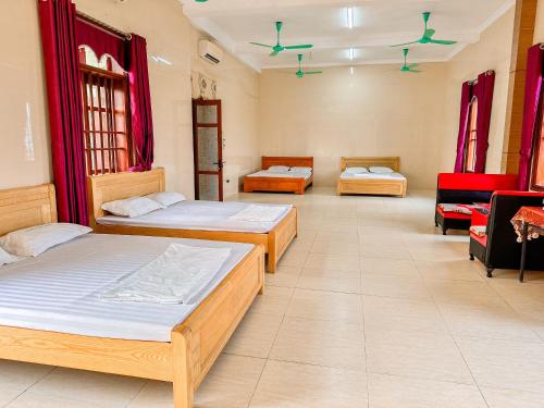 3 Betten in einem Zimmer mit roten Vorhängen in der Unterkunft Lake View Ninh Binh in Tam Ðiệp