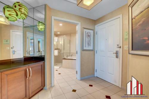 La salle de bains est pourvue d'un lavabo et d'une porte blanche. dans l'établissement MGM Signature 15-603 Strip View Jacuzzi Studio, à Las Vegas