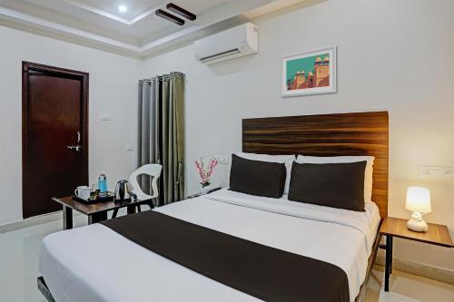 a bedroom with a large bed with a wooden headboard at Hotel White Ridge Near Kondapur in Kondapur