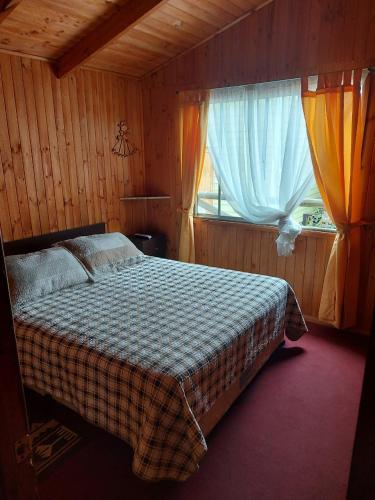 a bedroom with a bed and a window at Cabañas frente al mar 