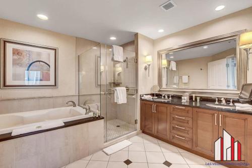 a bathroom with a tub and a sink and a shower at MGM Signature-21-609 Strip View Jacuzzi Studio in Las Vegas