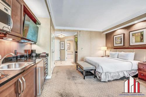 a large hotel room with a bed and a sink at MGM Signature-21-609 Strip View Jacuzzi Studio in Las Vegas