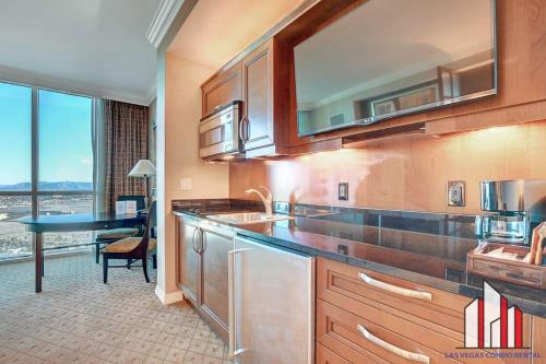 a kitchen with a sink and a desk in a room at MGM Signature-28-816 Jacuzzi Studio in Las Vegas