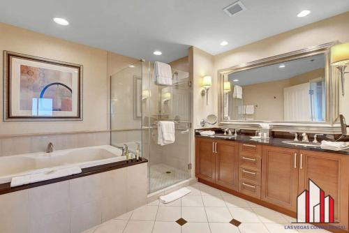 een badkamer met een bad, een douche en een wastafel bij MGM Signature-28-816 Jacuzzi Studio in Las Vegas