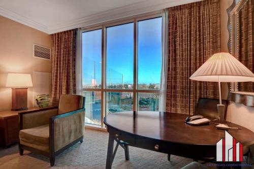 a hotel room with a desk and a large window at MGM Signature-04-704 Jacuzzi Studio in Las Vegas