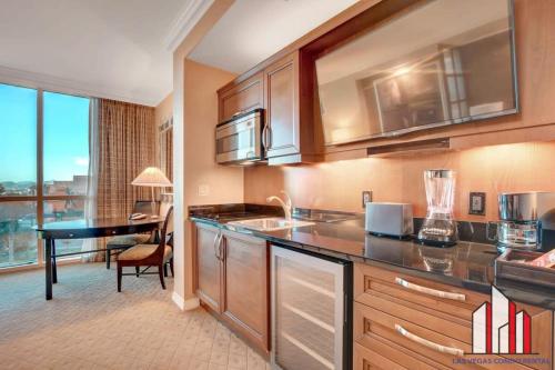 a kitchen with a sink and a desk in a room at MGM Signature-04-704 Jacuzzi Studio in Las Vegas
