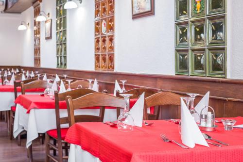 a dining room with red and white tables and chairs at Hotel Piroska in Bük