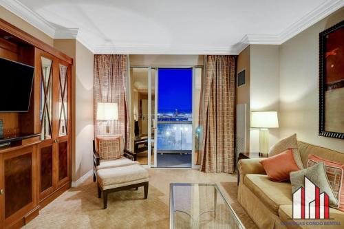 a living room with a couch and a tv at MGM Signature-10-714 1Br Balcony Suite Accessible in Las Vegas