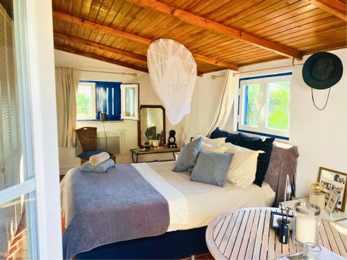 een slaapkamer met een groot bed en een tafel bij João Jungle in Açafora