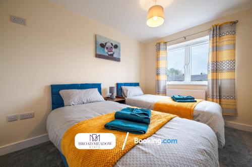 two beds in a room with a window at 2 Bedroom, Brand new property By Broad Meadow Stays Short Lets and Serviced Accommodation Lincoln With Garden in Lincoln