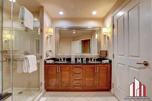 een badkamer met een wastafel en een spiegel bij MGM Signature-30-719 Strip View Jacuzzi Studio in Las Vegas