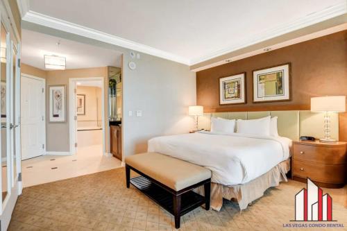 a large bedroom with a large white bed and a stool at MGM Signature-16-704 Jacuzzi Studio in Las Vegas