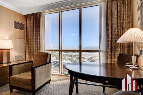 a room with a desk and a table and a window at MGM Signature-16-704 Jacuzzi Studio in Las Vegas