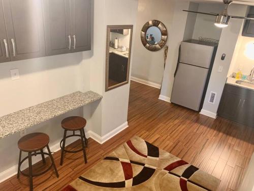 a kitchen with a counter and two stools and a refrigerator at The House Hotels - W45th Backhouse - Ohio City District Home - 5 Minutes from Downtown in Cleveland