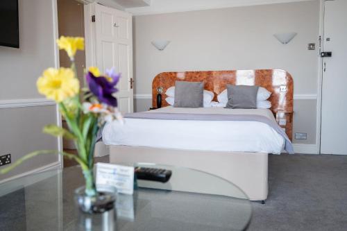 a bedroom with a bed and a vase of flowers at The Lanes Hotel in Brighton & Hove