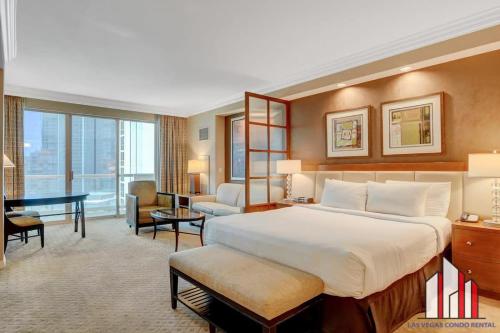 um quarto de hotel com uma cama grande e uma escrivaninha em MGM Signature-10-717 Strip View Balcony Studio em Las Vegas