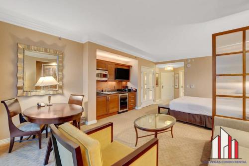 a hotel room with a bed and a desk and a table at MGM Signature-11-704 Jacuzzi Studio in Las Vegas