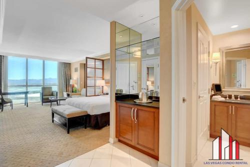 een slaapkamer met een bed en een badkamer met een wastafel bij MGM Signature-17-606 Jacuzzi Studio in Las Vegas