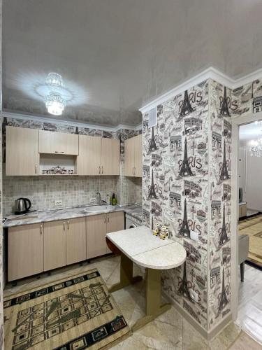 a kitchen with a table and a wall covered in stickers at Апартаменты "Комфорт и уют" in Aktau