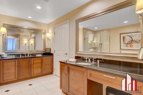 a bathroom with a sink and a large mirror at MGM Signature-29-602 1Br 2Ba Balcony Jacuzzi Suite in Las Vegas