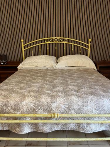 a bed with a metal frame and two pillows at Da Adriana Guesthouse in Santa Teresa Gallura