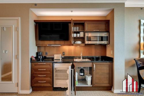 a kitchen with wooden cabinets and a sink at MGM Signature-17-718 Jacuzzi Studio in Las Vegas