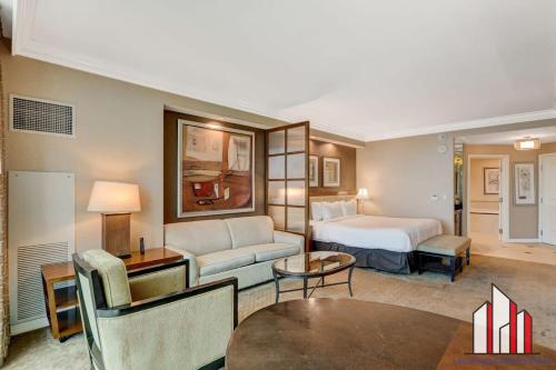 a hotel room with a bed and a couch at MGM Signature-17-718 Jacuzzi Studio in Las Vegas
