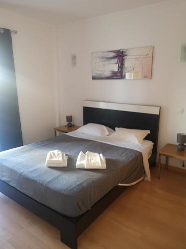 a bedroom with a bed with two towels on it at Rocha T Apartments in Portimão