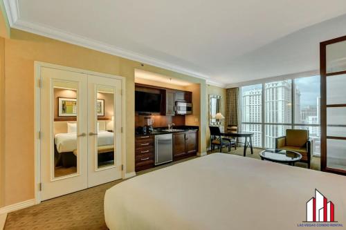 a hotel room with a large bed and a kitchen at MGM Signature-22-611 Strip View Jacuzzi Studio in Las Vegas