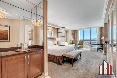 a hotel room with a bed and a desk and a kitchen at MGM Signature-15-604 Jacuzzi Studio in Las Vegas