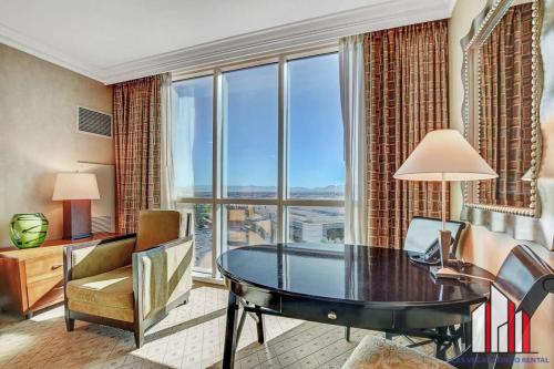 a living room with a table and a large window at MGM Signature-15-604 Jacuzzi Studio in Las Vegas