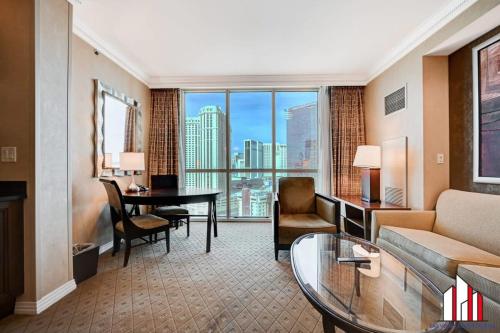 a living room with a couch and a table in a hotel room at MGM Signature-15-611 Strip View Jacuzzi Studio in Las Vegas