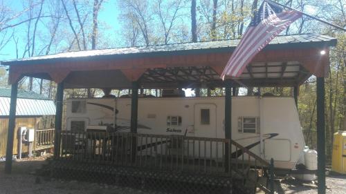 Una caravana con una bandera americana. en Two Creeks Camp, en Athens