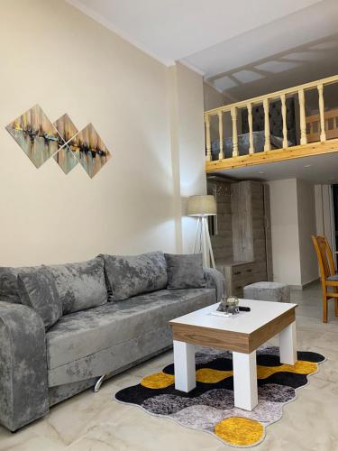 a living room with a couch and a coffee table at Troy ApartHotel Durres in Durrës
