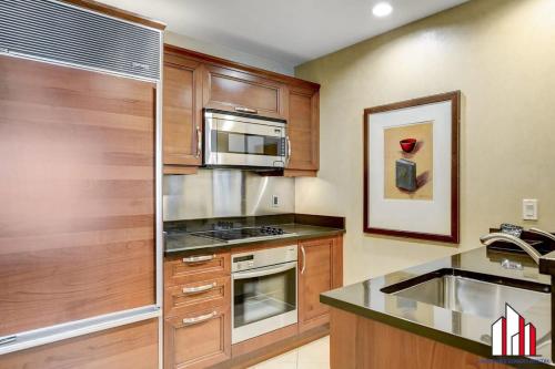 a kitchen with wooden cabinets and a stove top oven at MGM Signature-07-620 1Br 2Ba Balcony Suite in Las Vegas