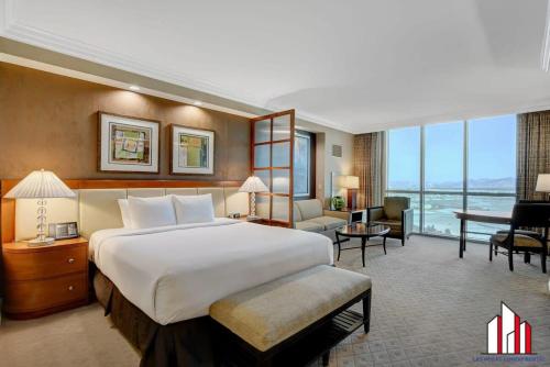 a hotel room with a large bed and a living room at MGM Signature-24-716 Jacuzzi Studio in Las Vegas