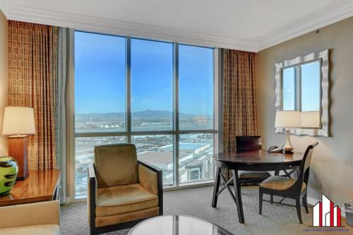 a hotel room with a desk and a table with a view at MGM Signature-24-716 Jacuzzi Studio in Las Vegas