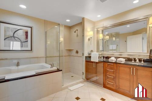 a bathroom with a tub and a shower and a sink at MGM Signature-24-716 Jacuzzi Studio in Las Vegas