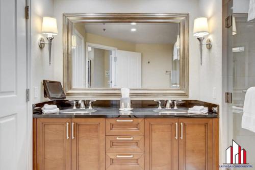 a bathroom with two sinks and a large mirror at MGM Signature-24-606 Jacuzzi Studio in Las Vegas