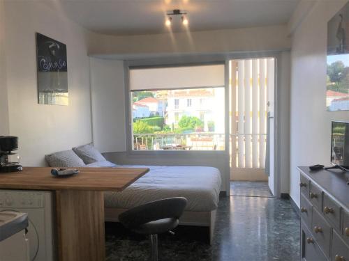 une chambre avec un lit, un bureau et une fenêtre dans l'établissement Cannes center AC Wi-fi terrace 200 m sea Croisette, à Cannes