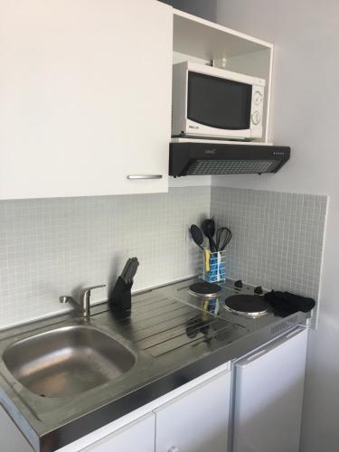 une cuisine avec un évier et un micro-ondes dans l'établissement Cannes center AC Wi-fi terrace 200 m sea Croisette, à Cannes