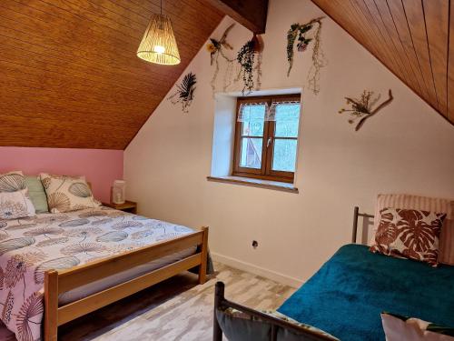 une chambre avec un lit et une fenêtre dans l'établissement Gite Fée Grenouille, à Martigny-le-Comte