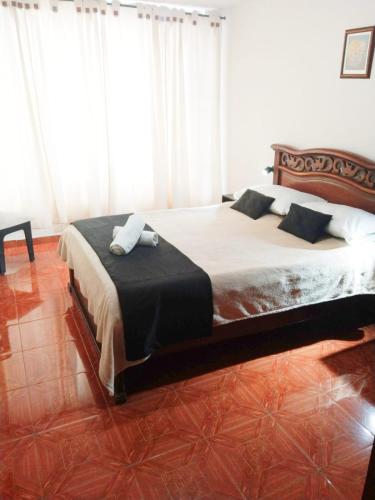 1 dormitorio con 1 cama grande con sábanas y almohadas blancas en Habitaciones cerca al aeropuerto centro y centro conecta embajada americana, en Bogotá