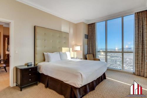 MGM Signature-31-702 1Bedroom 2Bath Balcony Suite في لاس فيغاس: غرفة فندقية بسرير كبير ونوافذ كبيرة