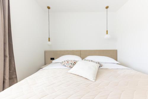 a white bed with two pillows on it at Villa Koludrovac in Kaštela